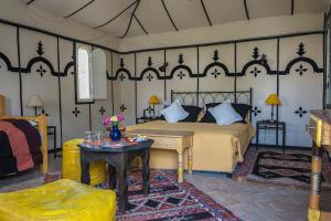 una camera da letto con un letto e un tavolo di Hotel Dar Zitoune Taroudant a Taroudant