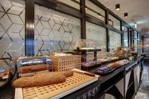 a bakery with a counter with food on display at Vienna House Easy by Wyndham Dortmund City in Dortmund