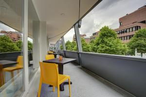 a table and chairs on a balcony with a view at NYCE Hotel Dortmund City in Dortmund