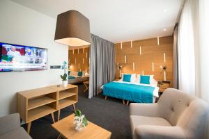 een hotelkamer met een bed en een bank bij Hotel Sana in Sarajevo