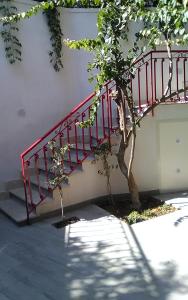 レトイアンニにあるPoggio del Soleの建物の隣の木の横の赤い階段