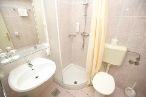 a bathroom with a shower and a toilet and a sink at Hotel Donat - All Inclusive in Zadar