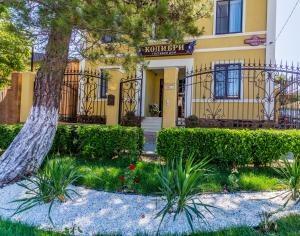 una casa gialla con un albero di fronte di Guest house Kolibri a Gelendzhik