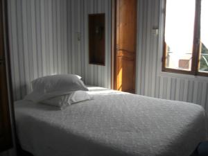 a bedroom with a white bed with a window at La Marjolaine in Juan-les-Pins