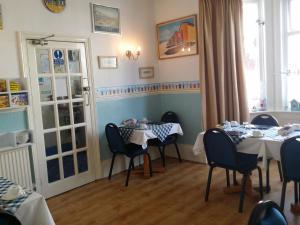 comedor con 2 mesas y sillas en The Beach House, en Great Yarmouth