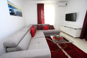 sala de estar con sofá gris y TV en Villa Domus, en Podstrana