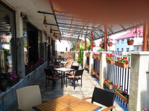 an outdoor patio with tables and chairs and flowers at Apartament NORA in Braşov