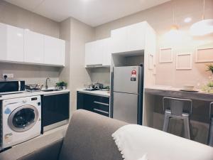 a kitchen with a couch and a refrigerator at KL Gateway Residency in Kuala Lumpur