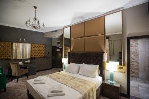 Peninsula Boutique Hotel في كونستانتا: غرفة في الفندق مع سرير ومكتب