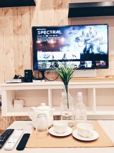 a desk with a computer monitor and a vase of flowers at KL Gateway Residency in Kuala Lumpur