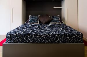 a bedroom with a bed with a black and white comforter at P&D Apartments Navigli in Milan