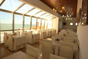 a room with white tables and chairs and windows at Hotel SKY in San Bernardo
