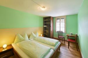 1 dormitorio con 1 cama y 1 mesa con silla en Budget Waldhotel Unspunnen en Interlaken