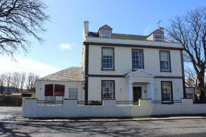 an old white house with a roof at The Southfield Hotel in Girvan