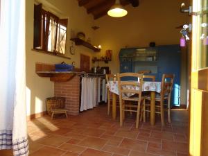 a kitchen with a table and chairs in a room at La Fattoria al Crocefisso in Pieve Fosciana