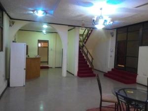 Nass Lodge في Sunyani: غرفة بها درج وطاولة وكراسي