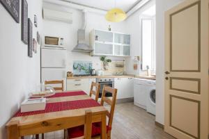 a kitchen with a dining room table and a kitchen with white appliances at Cuore di Testaccio Apartment in Rome