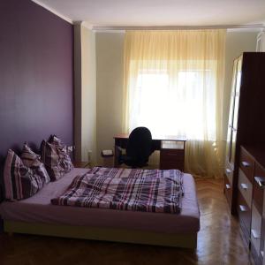um quarto com uma cama, uma secretária e uma janela em Krisztina Vendégház em Keszthely
