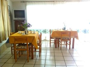 a dining room with two tables and chairs and a television at B&b Sa Domo in San Teodoro