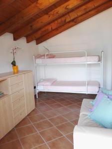 レッツェノにあるCa' Eleonoraの二段ベッド2台とソファが備わる客室です。