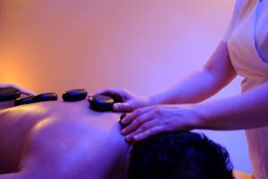 a woman getting a massage on the back of a man at Villa Nicolli Romantic Spa Resort - Adults Only in Riva del Garda