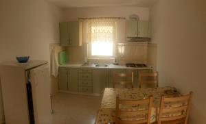 a kitchen with a sink and a table and chairs at Apartments Mesec in Igrane