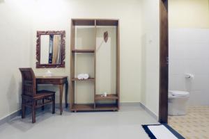 烏布的住宿－烏布龐多克蒙德旅館，一间带书桌、镜子和卫生间的浴室