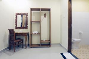 a bathroom with a desk and a mirror and a toilet at Pondok Mundeh Ubud in Ubud