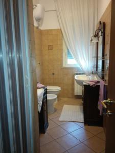 モンテジルヴァーノにあるB&B Colle Forestaのバスルーム(洗面台、トイレ付)、窓が備わります。
