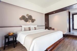a bedroom with a large white bed and a window at Sarikantang Resort & Spa, Koh Phangan in Haad Rin