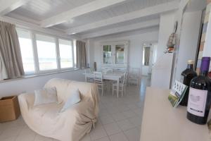 トッレ・ラピッロにあるAttico Lux Vista Mare - Spiaggia a 50 Mのリビングルーム(ソファ、ワインボトル付きテーブル付)