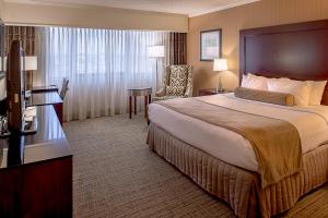 a hotel room with a large bed and a chair at Crowne Plaza Hotel St. Louis Airport, an IHG Hotel in Bridgeton
