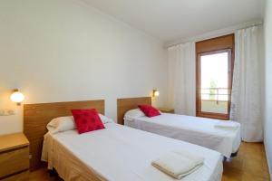 two beds in a room with a window at Costabravaforrent Masferrer in L'Escala