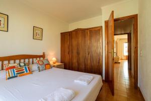 a bedroom with a white bed with a wooden headboard at Costabravaforrent Masferrer in L'Escala