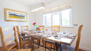 a dining room with a wooden table and chairs at Twiga House Bed and Breakfast in Wareham