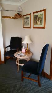 Habitación con 2 sillas, mesa y lámpara en Great Danes Country Inn, en Swaffham
