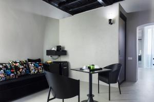 ein Wohnzimmer mit einem Tisch und einem Sofa in der Unterkunft Casa de' Coronari Suites in Rom