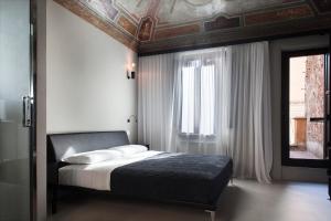 Schlafzimmer mit einem Bett mit einer Decke und einem Fenster in der Unterkunft Casa de' Coronari Suites in Rom