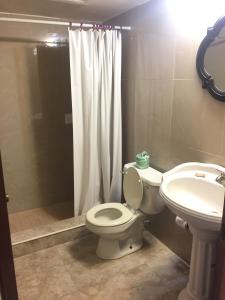 a bathroom with a toilet and a sink and a shower at Sun Fun Hotel in Nassau