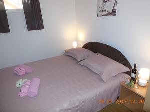 łóżko z fioletowymi poduszkami i fioletowymi ręcznikami w obiekcie Sobe Žalac w mieście Karlovac