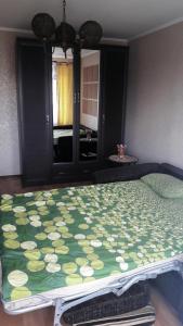 カリーニングラードにあるАпартаменты на 9 Апреляのベッドルーム1室(緑と白の毛布付きのベッド1台付)