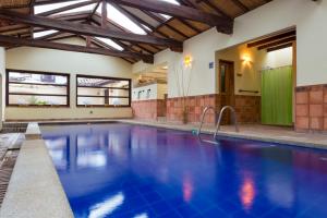 an indoor swimming pool with blue water in a building at Hotel y Spa Getsemani in Villa de Leyva