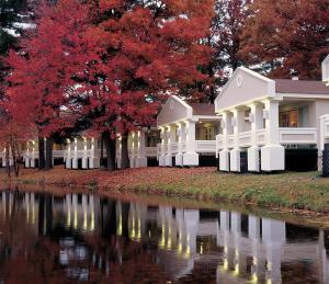una casa con árboles rojos y un río en Paradise Stream Resort, en Cresco