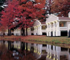 una casa con árboles rojos y un río en Paradise Stream Resort en Mount Pocono