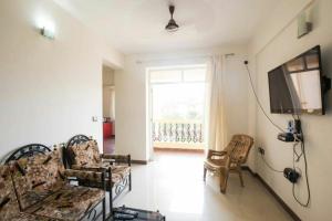a living room with a couch and chairs and a television at Dona Rosa Holiday Apartment in Varca