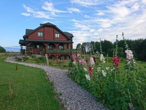 a large red house with flowers in front of it at Mazurski Staw in Gołdap