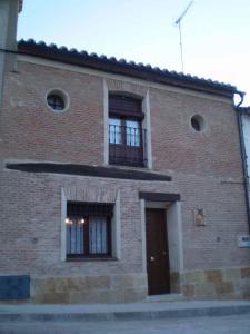 Casa Rural Calderon de Medina III في Siete Iglesias de Trabancos: مبنى من الطوب مع نافذتين وباب