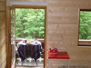 a table on the porch of a cabin with a window at Spacious Swiss Alpine Chalet for Nature Lovers in Val-d'Illiez