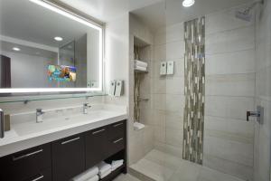 a bathroom with a shower, sink, and mirror at Bucuti & Tara Boutique Beach Resort - Adult Only in Palm-Eagle Beach