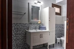 a bathroom with a sink and a mirror at Kouros Studios in Kavála